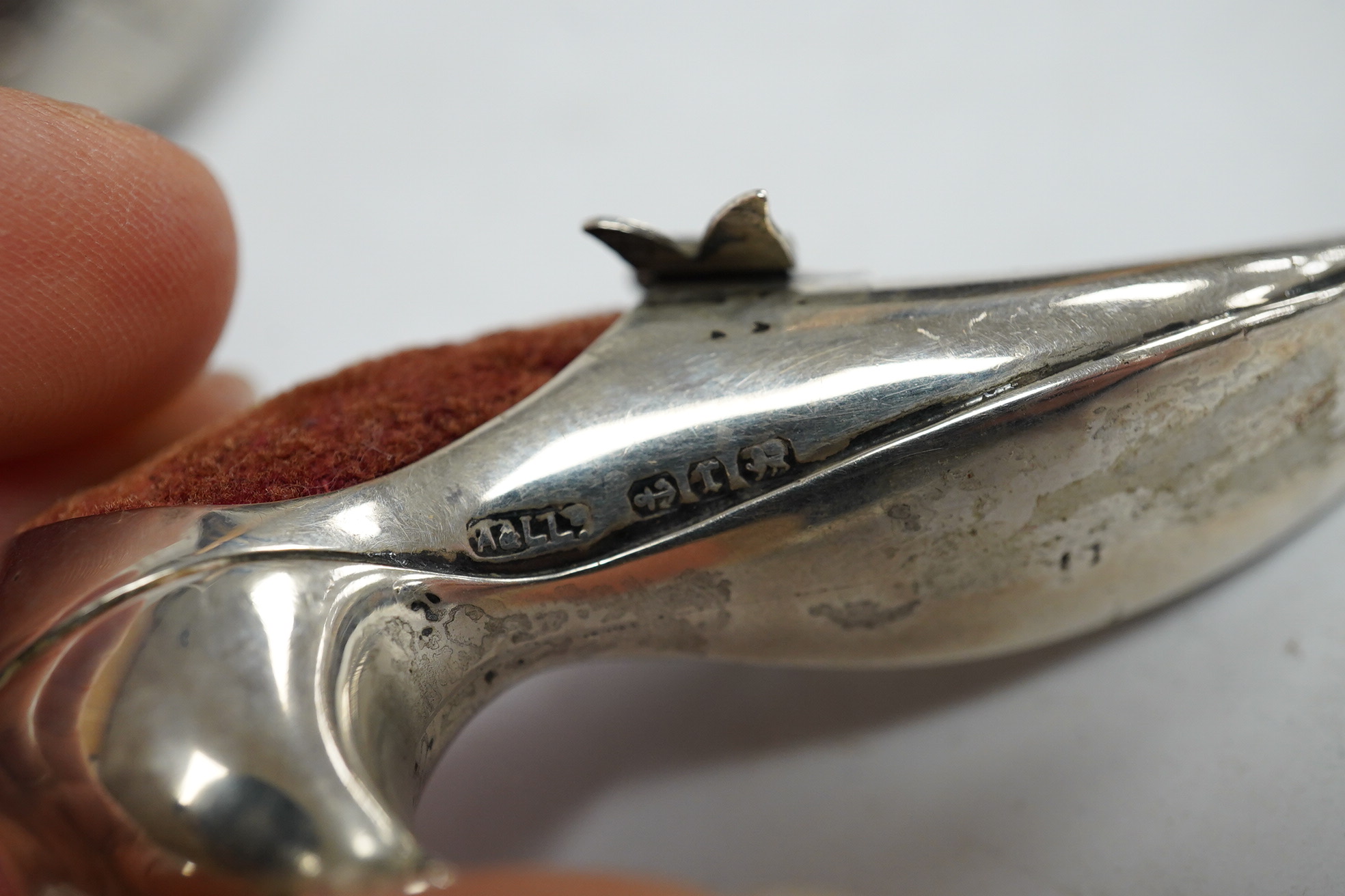 An Edwardian novelty silver pin cushion, modelled as a hatching chick, by Sampson Mordan & Co, Sheffield, 1906, height 43mm (hole), together with a late Victorian shoe pin cushion, by Adie & Lovekin, Birmingham, 1892, Co